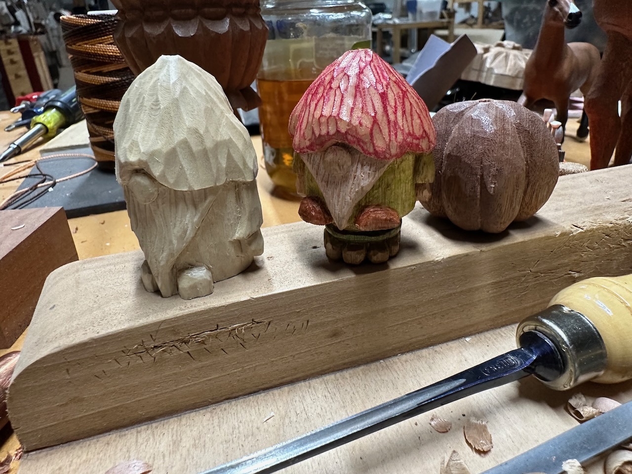 Four hand carved beads on the workbench. Photo by author.